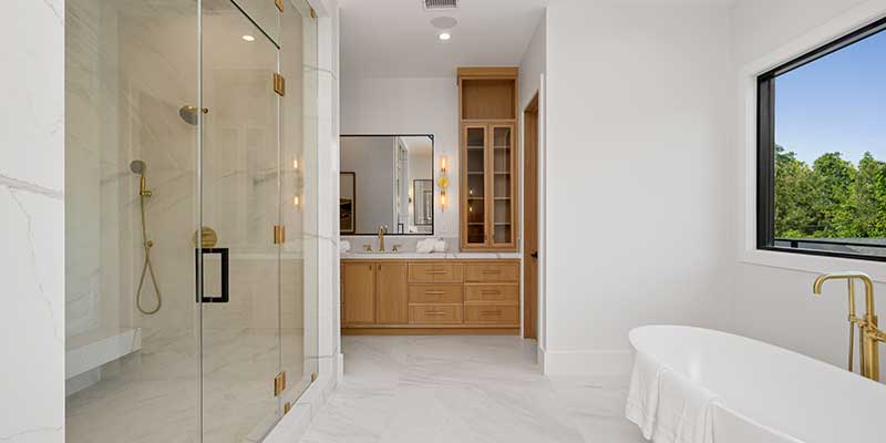 A frameless glass shower next to a freestanding tub or recessed soaking